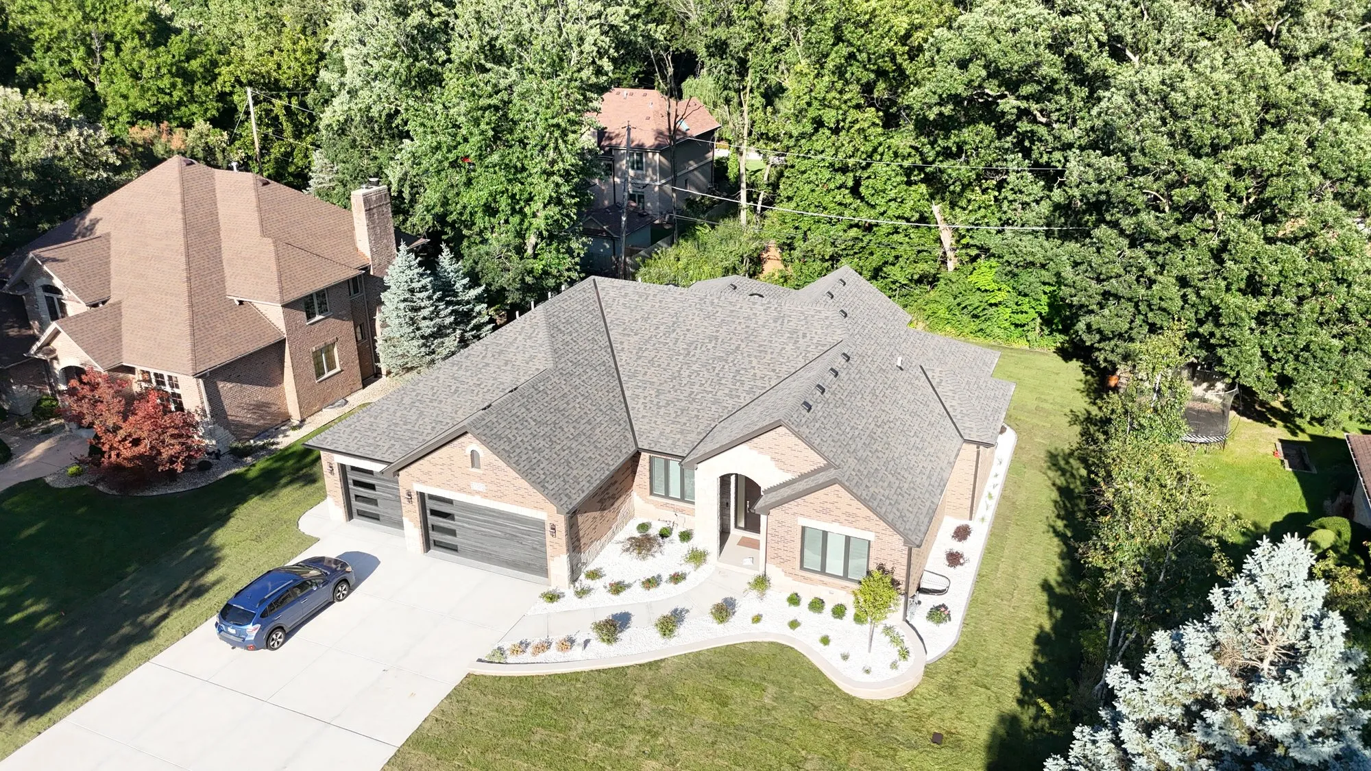 Aerial drone view of a premium brick home with manicured landscaping in Tinley Park, Illinois