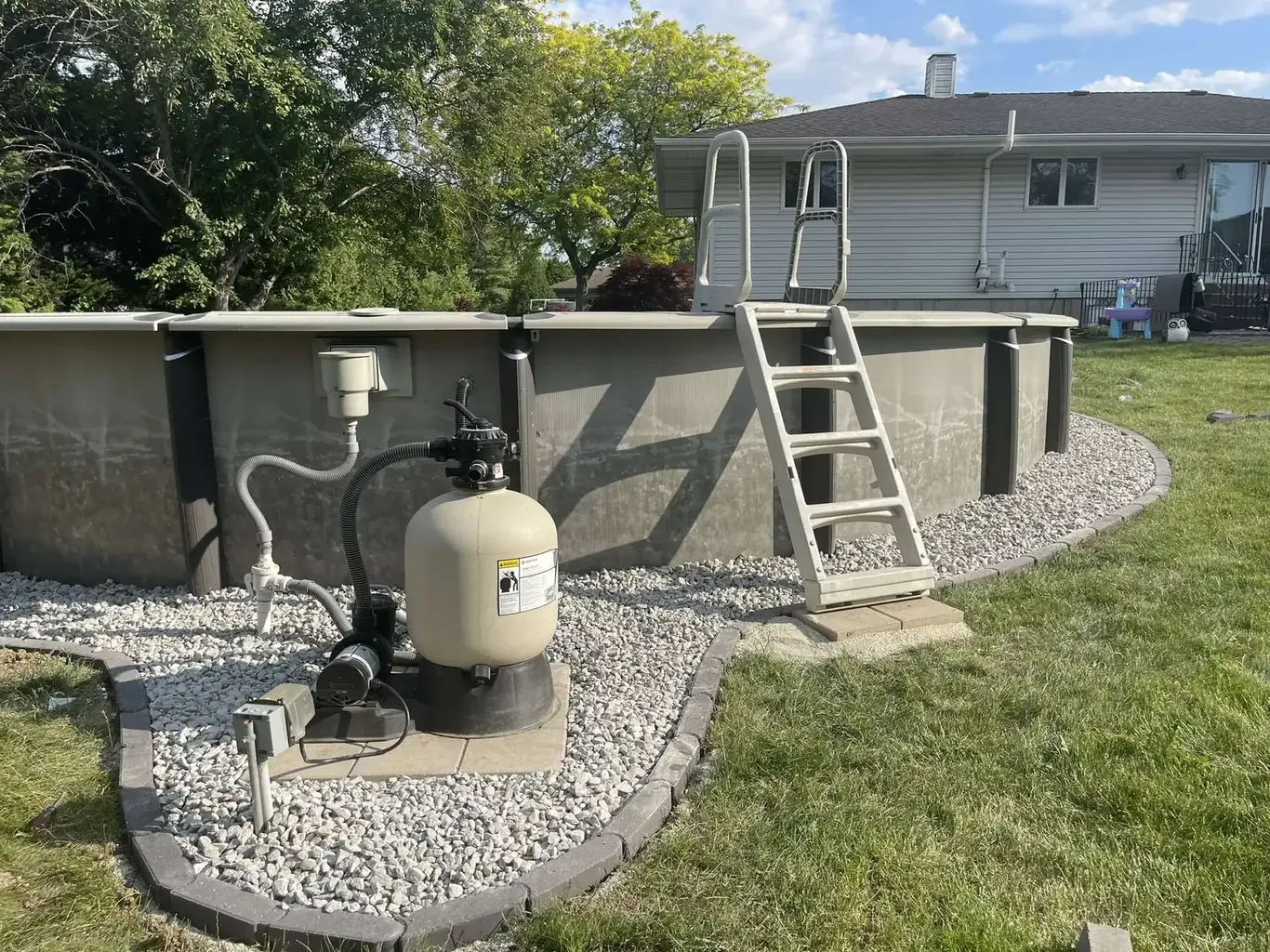 Finished pool patios & surrounds in the southwest suburbs by Rodak Landscaping: Above-Ground Pool with Stone-Border Gravel Pad