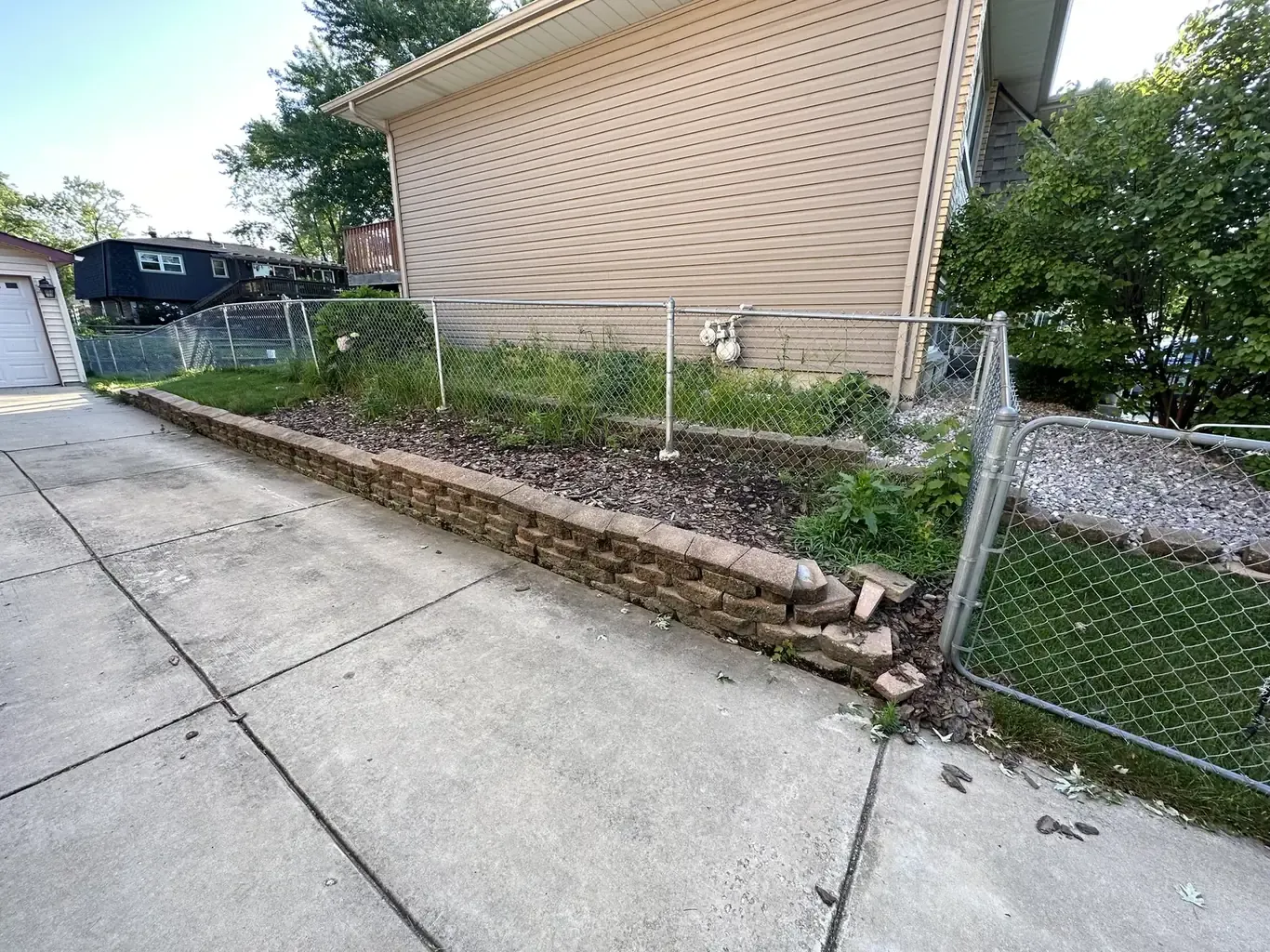 Before: Tinley Park Driveway Stone Retaining Wall Rebuild by Rodak Landscaping